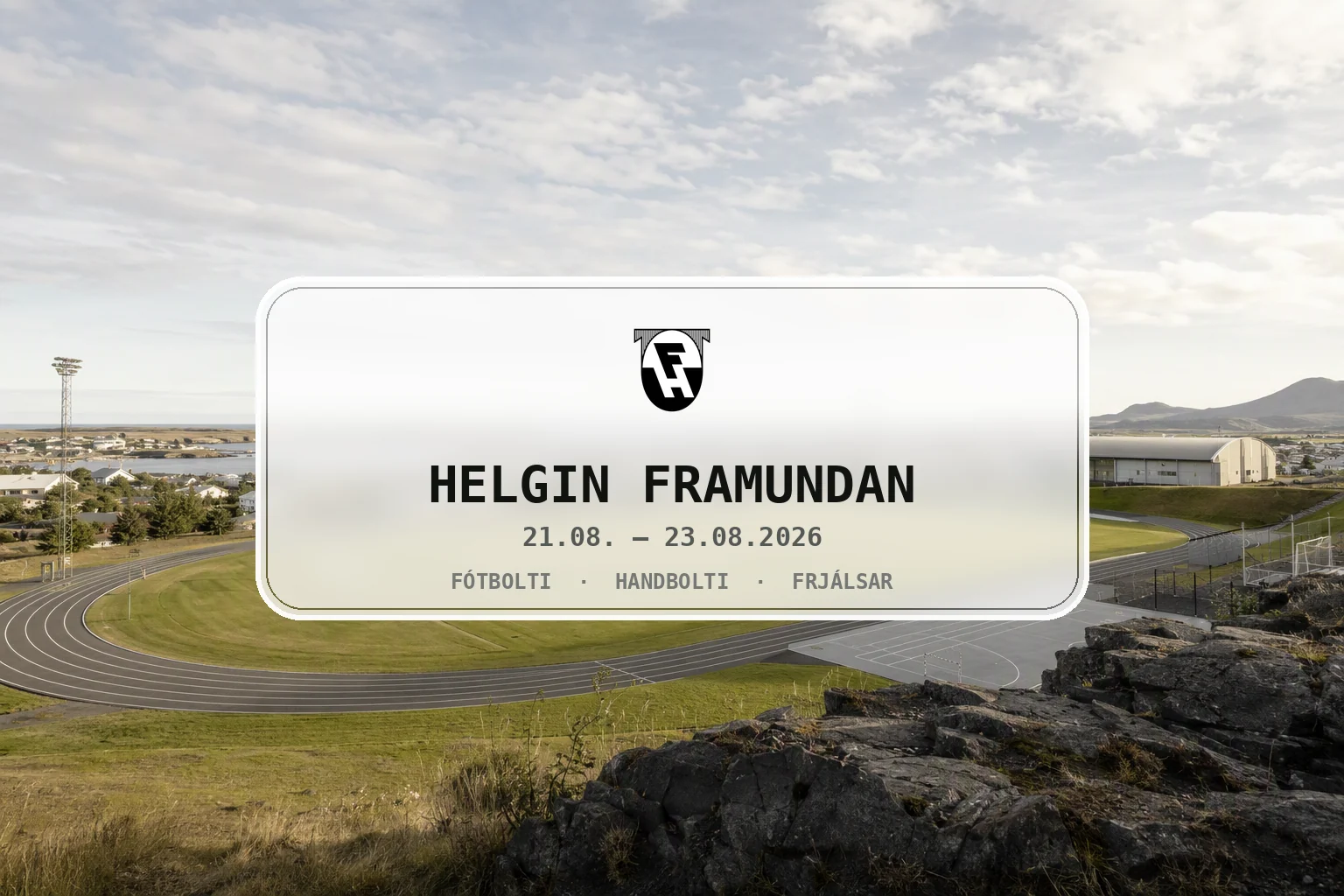 Björt síðsumarmynd af íþróttasvæði og bæjarlandslagi í Hafnarfirði.